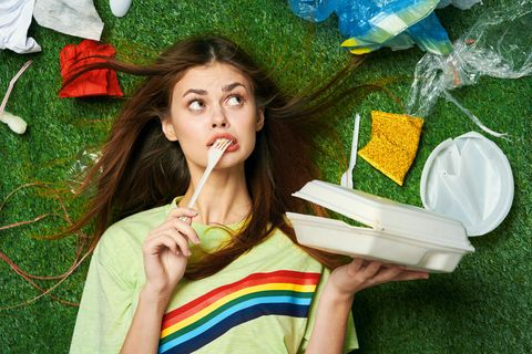 o femeie înconjurată de materiale plastice de unică folosință